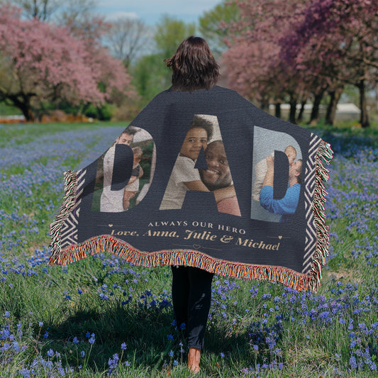 Person holding a personalized blanket with family photos and text in a field of flowers.